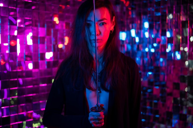 young woman standing against illuminated string lights