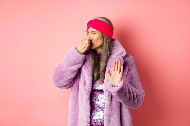 Photo young woman standing against pink background