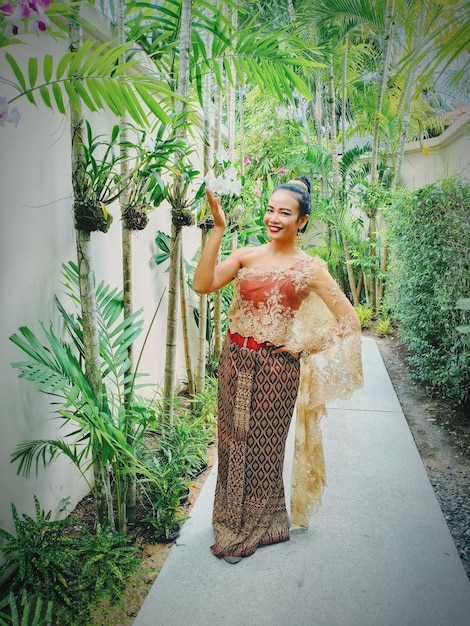 Photo young woman standing against plants