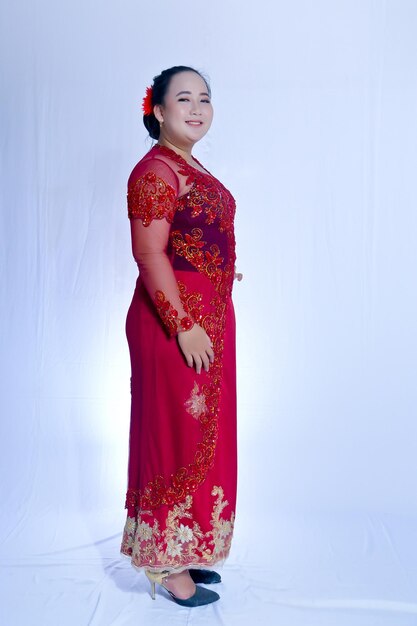 Photo young woman standing against red wall