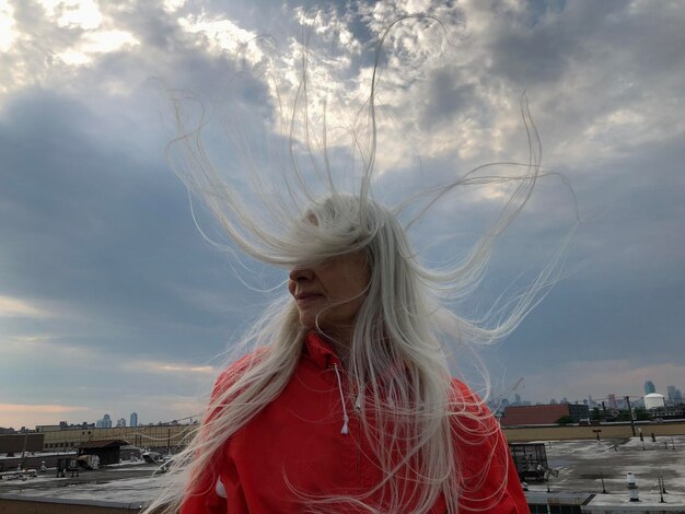 Young woman standing against sky during sunset