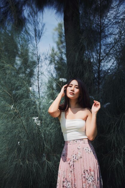 Photo young woman standing against tree