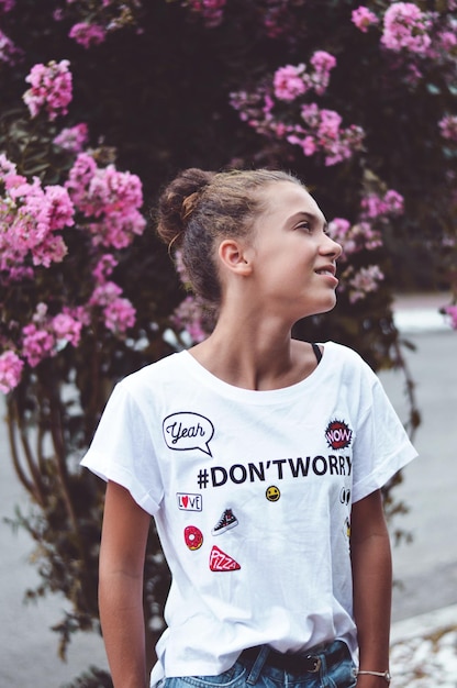 Photo young woman standing against tree