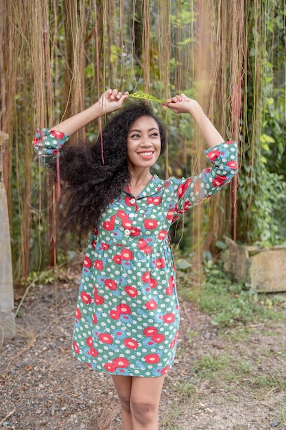 Young woman standing against trees