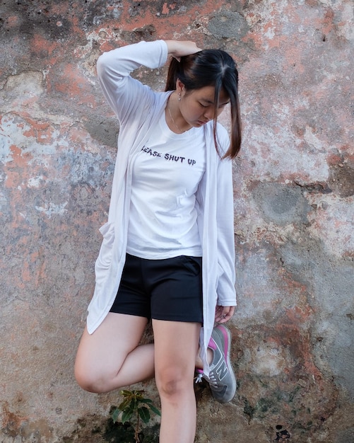 Young woman standing against wall