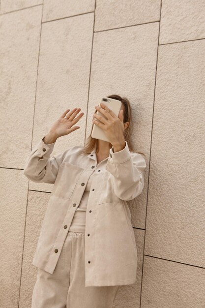 Foto giovane donna in piedi contro il muro