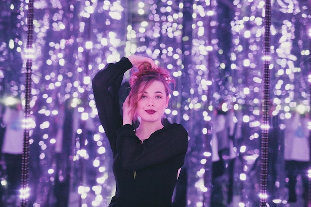 Young woman standing against wall