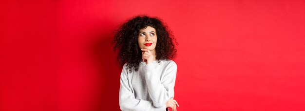 Young woman standing against yellow background