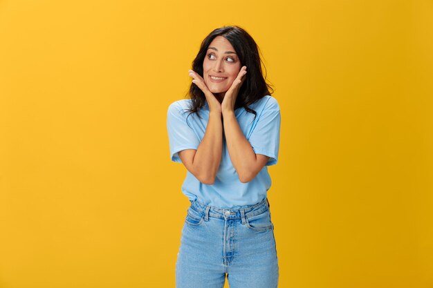 Young woman standing against yellow background