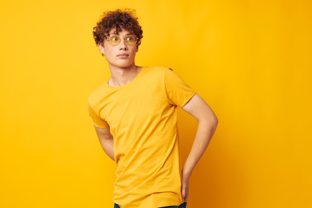 Young woman standing against yellow background