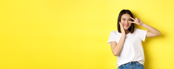 Photo 黄色い背景に立っている若い女性