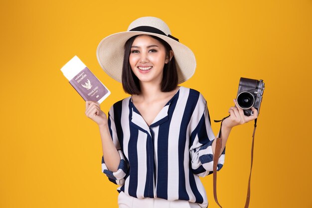 Young woman standing against yellow background