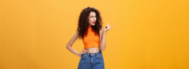 Young woman standing against yellow background