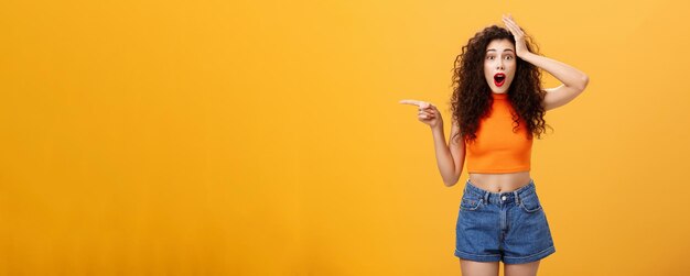 Young woman standing against yellow background