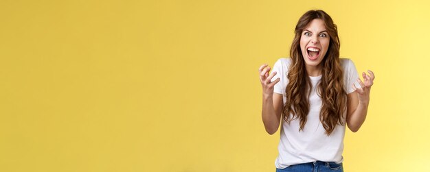 Foto giovane donna in piedi su uno sfondo giallo