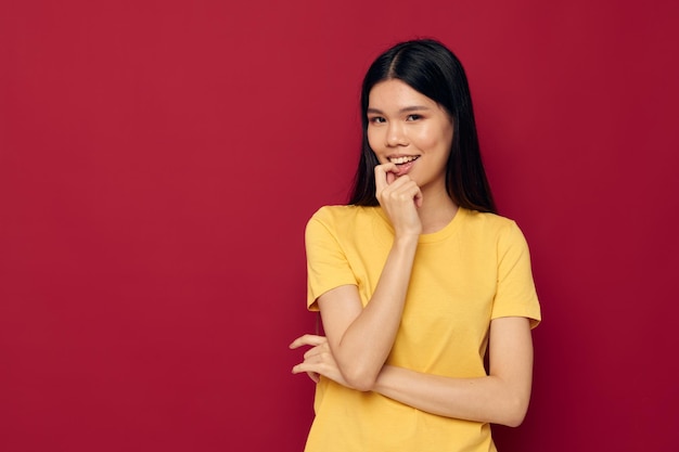 Young woman standing against yellow background