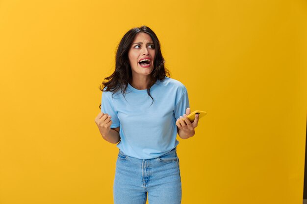 Young woman standing against yellow background