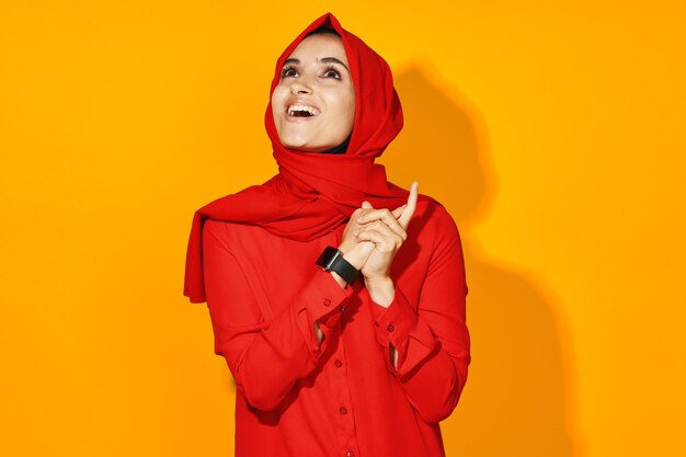 Young woman standing against yellow background