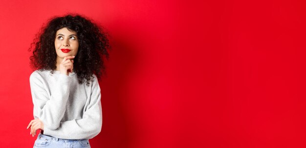 Young woman standing against yellow background