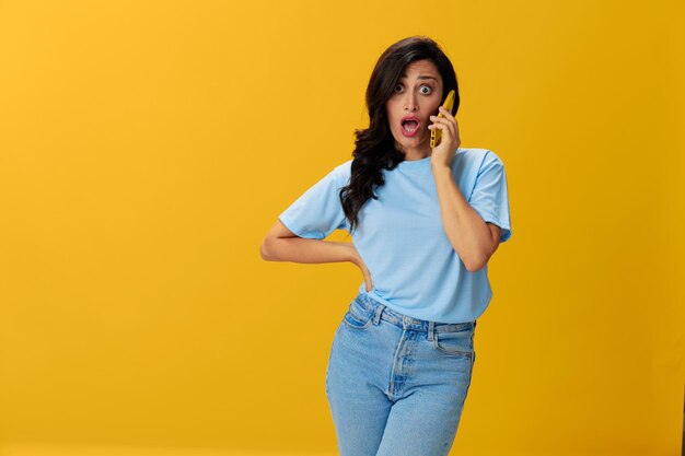 Young woman standing against yellow background