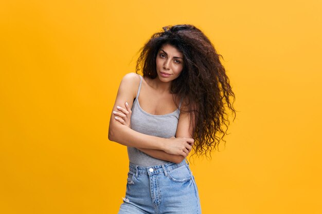 Young woman standing against yellow background