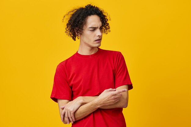 Young woman standing against yellow background