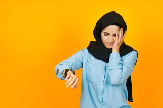 Young woman standing against yellow background