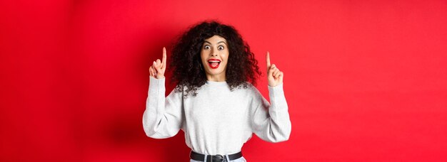 Young woman standing against yellow wall