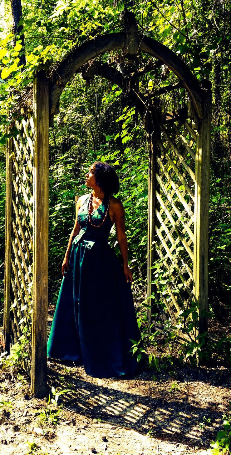 Photo young woman standing in archway at park