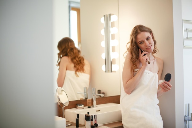 Young woman standing on bathroom with phone