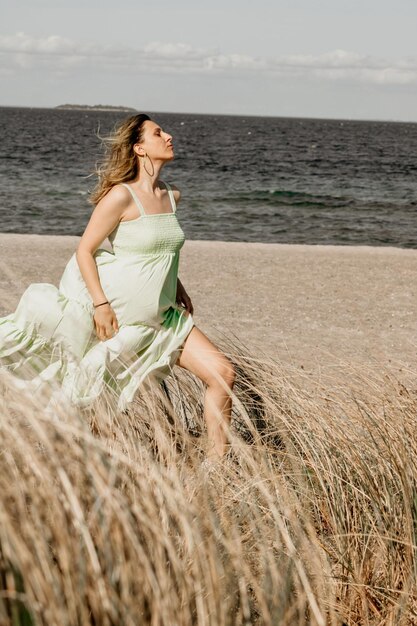 Foto giovane donna in piedi sulla spiaggia