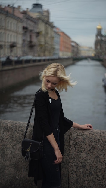 Young woman standing on bridge over river against sky