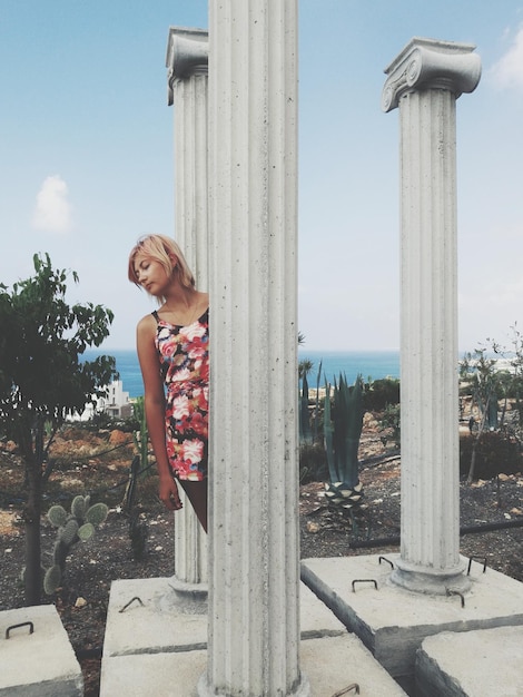 Foto giovane donna in piedi accanto a colonne architettoniche