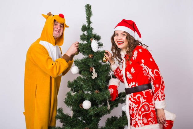 Young woman standing by christmas tree during winter