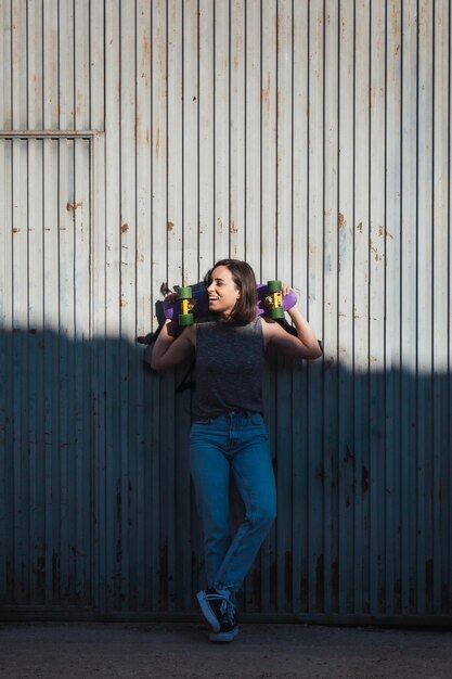 Photo young woman standing by corrugated iron