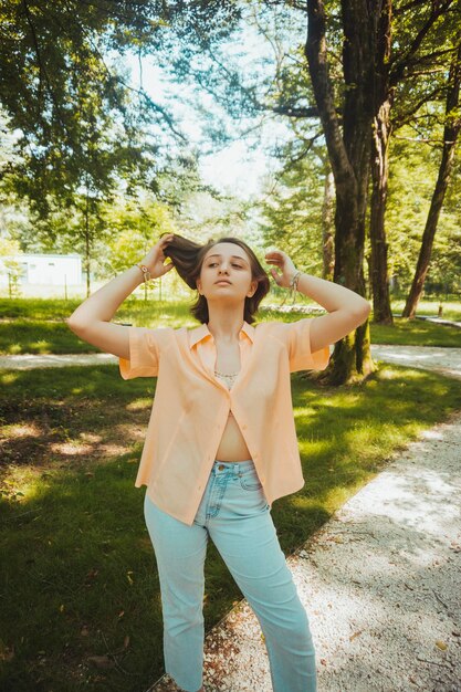 Young woman standing by tree on field