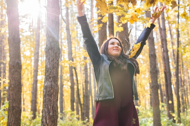 Young woman standing by tree trunk in forest