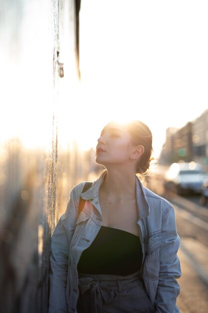 사진 하늘을 향해 도시의 벽에 서 있는 젊은 여성