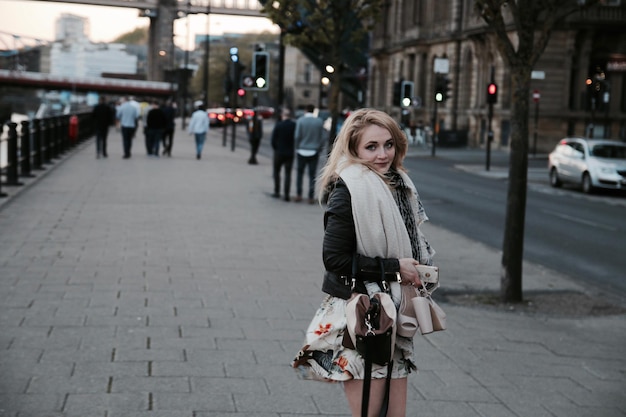 young woman standing on city street