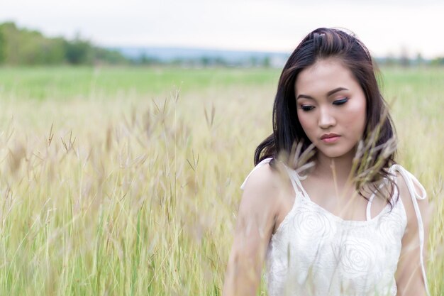 Young woman standing on field against sky