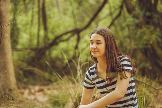 Photo young woman standing in forest