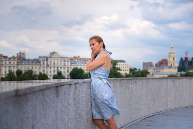 Young woman standing in front of clouds