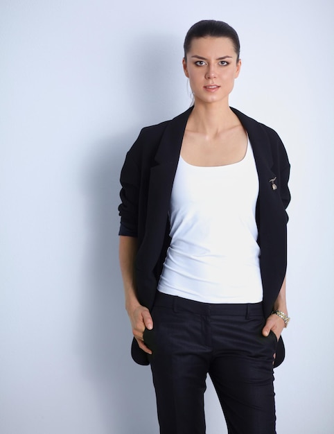 Young woman standing, isolated on gray background