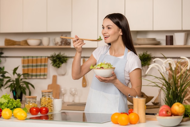 Giovane donna in piedi in cucina