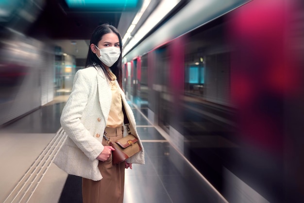 地下鉄の交通機関に立っている若い女性