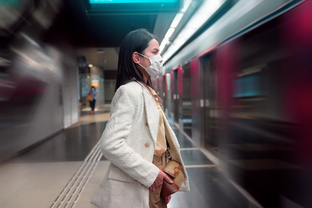 A young woman standing in metro transportation