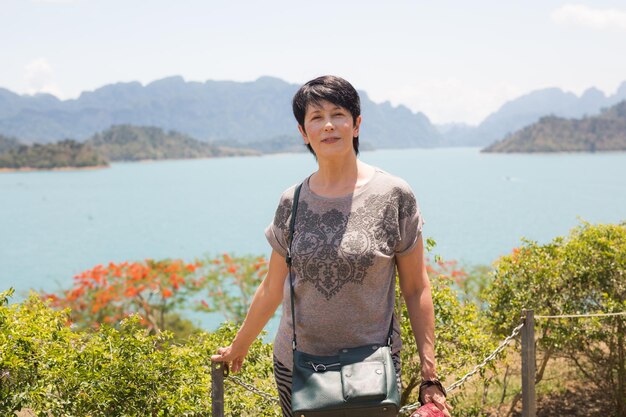 Foto giovane donna in piedi sulla montagna contro il mare