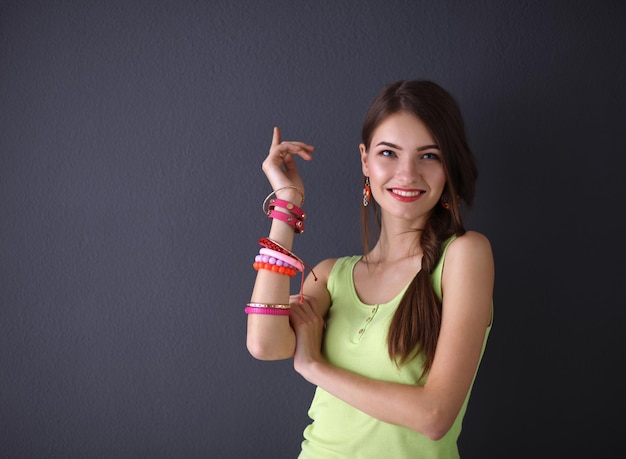 Young woman standing near dark wall