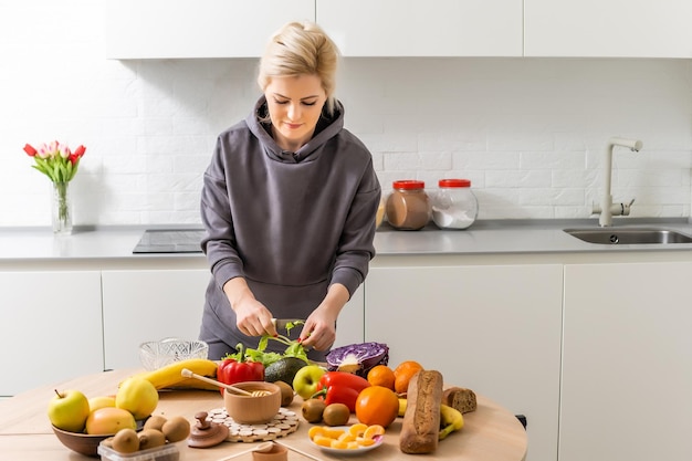 Young woman standing near desk in the kitchen.