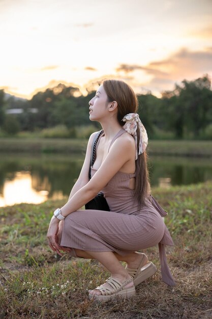 Foto giovane donna in piedi vicino al lago durante il tramonto bellissima natura